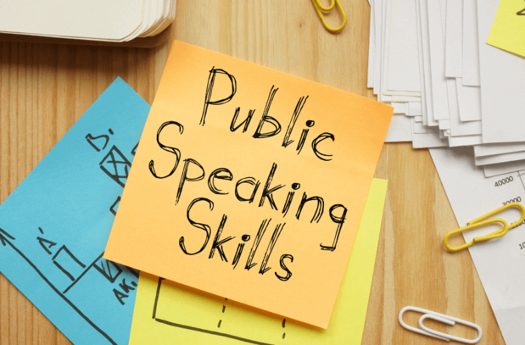 Post it notes with an orange one on top with the words public speaking skills on it